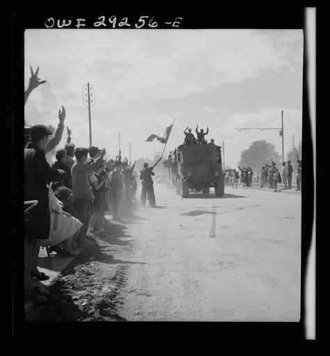 French citizens wave tricolor as the trucks of the Allied Armies enter the outskirts of Tunis