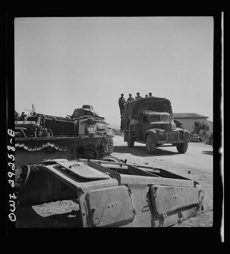 Porto Farina, Tunisia. Allied truck passing wrecked German tanks