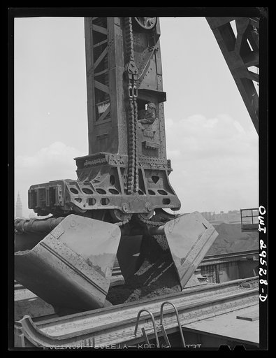 Cleveland, Ohio. Unloading iron ore by means of Hewlett [i.e., Hulett] unloaders at the Pennsylvania Railroad docks. Each bucket load weighs approximately seventeen tons
