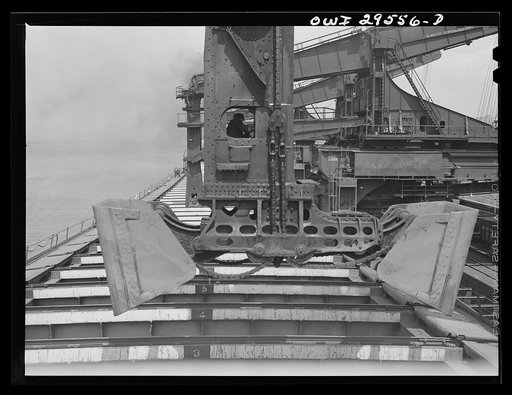 Untitled photo, possibly related to: Cleveland, Ohio. Unloading iron ore from a lake freighter by means of Hewlett [i.e., Hulett] unloaders at the Pennsylvania Railroad docks
