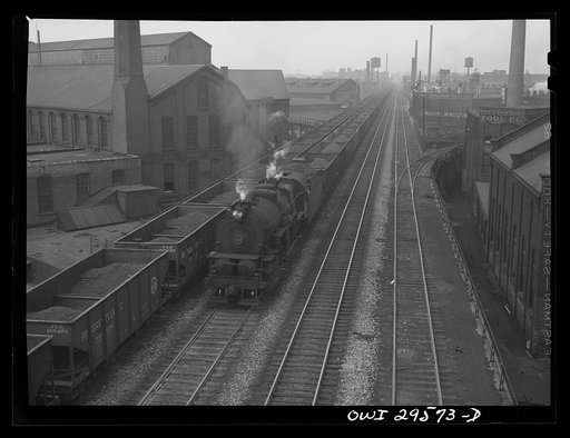 Untitled photo, possibly related to: Cleveland, Ohio. On the left, a Pennsylvania Railroad iron ore train about to leave for the steel mills; right, a Pennsylvania Railroad train is coming in from the coal mines