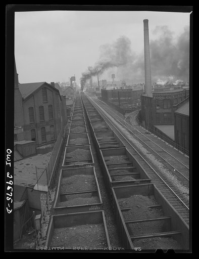 Untitled photo, possibly related to: Cleveland, Ohio. On the left, a Pennsylvania Railroad iron ore train about to leave for the steel mills; right, a Pennsylvania Railroad train is coming in from the coal mines