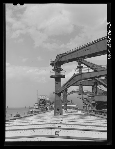 Untitled photo, possibly related to: Cleveland, Ohio. Unloading iron ore from a lake freighter by means of Hewlett [i.e., Hulett] unloaders at the Pennsylvania Railroad docks