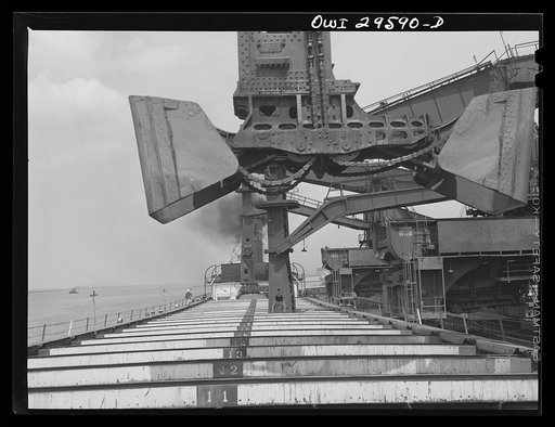 Untitled photo, possibly related to: Cleveland, Ohio. Unloading iron ore from a lake freighter by means of Hewlett [i.e., Hulett] unloaders at the Pennsylvania Railroad docks