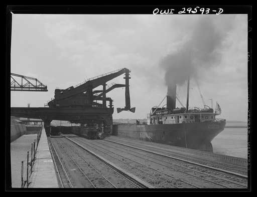 Untitled photo, possibly related to: Cleveland, Ohio. Unloading a lake freighter by means of Hewlett [i.e., Hulett] unloaders at the Pennsylvania Railroad iron ore docks