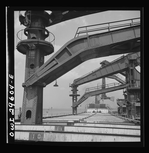 Untitled photo, possibly related to: Cleveland, Ohio. Unloading iron ore from a lake freighter by means of Hewlett [i.e., Hulett] unloaders at the Pennsylvania Railroad docks