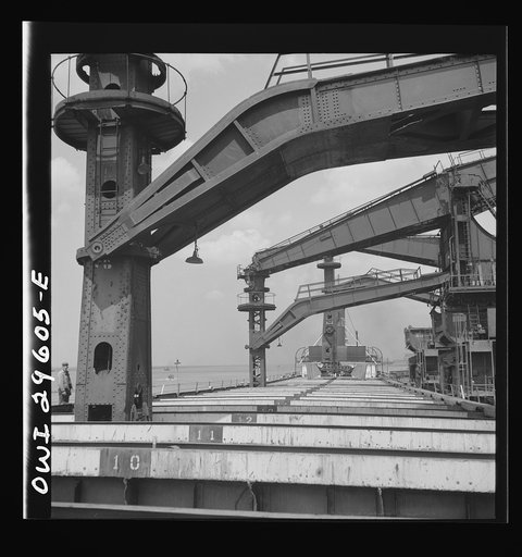 Untitled photo, possibly related to: Cleveland, Ohio. Unloading iron ore from a lake freighter by means of Hewlett [i.e., Hulett] unloaders at the Pennsylvania Railroad docks
