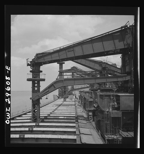 Untitled photo, possibly related to: Cleveland, Ohio. Unloading iron ore from a lake freighter by means of Hewlett [i.e., Hulett] unloaders at the Pennsylvania Railroad docks