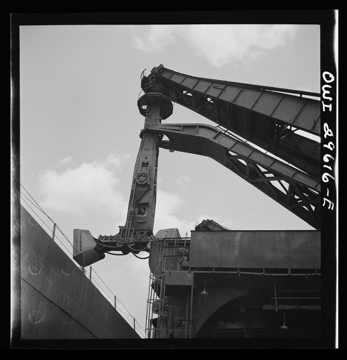 Untitled photo, possibly related to: Cleveland, Ohio. Unloading iron ore from a lake freighter by means of Hewlett [i.e., Hulett] unloaders at the Pennsylvania Railroad docks