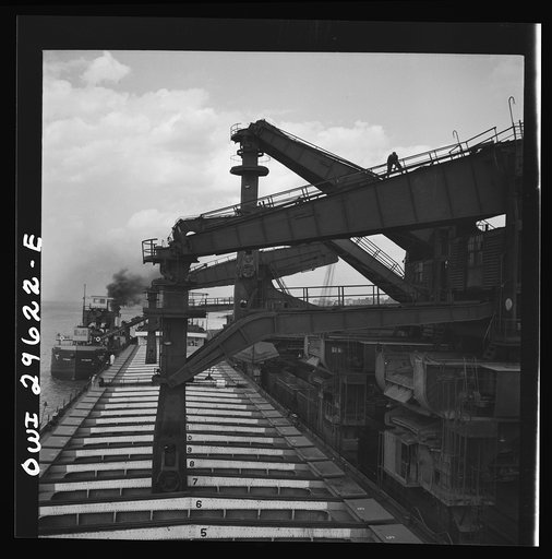 Untitled photo, possibly related to: Cleveland, Ohio. Unloading iron ore from a lake freighter by means of Hewlett [i.e., Hulett] unloaders at the Pennsylvania Railroad docks