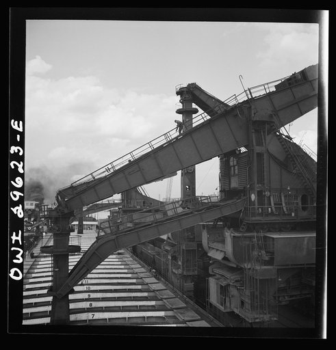 Untitled photo, possibly related to: Cleveland, Ohio. Unloading iron ore from a lake freighter by means of Hewlett [i.e., Hulett] unloaders at the Pennsylvania Railroad docks