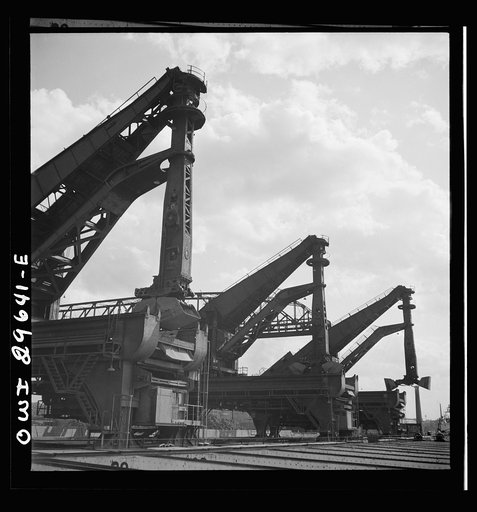 Untitled photo, possibly related to: Cleveland, Ohio. Unloading iron ore from a lake freighter by means of Hewlett [i.e., Hulett] unloaders at the Pennsylvania Railroad docks