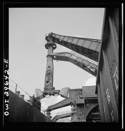 Untitled photo, possibly related to: Cleveland, Ohio. Unloading iron ore from a lake freighter by means of Hewlett [i.e., Hulett] unloaders at the Pennsylvania Railroad docks