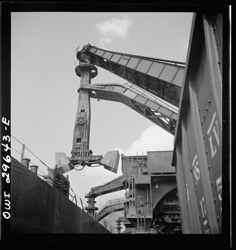 Untitled photo, possibly related to: Cleveland, Ohio. Unloading iron ore from a lake freighter by means of Hewlett [i.e., Hulett] unloaders at the Pennsylvania Railroad docks