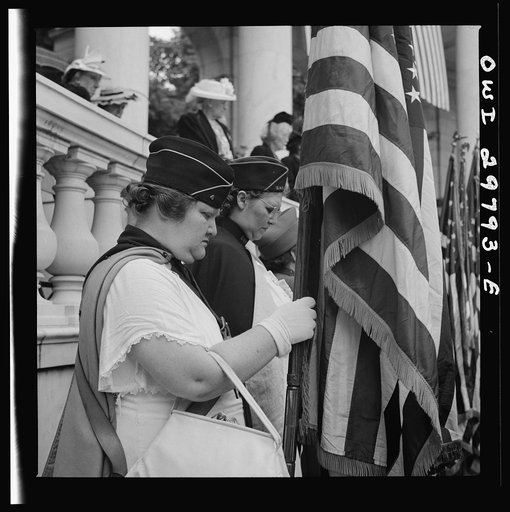 Arlington Cemetery, Arlington, Virginia. American Legion color bearer listening to "Taps" being played at the Memorial services in the amphitheater
