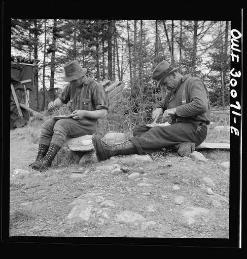 Untitled photo, possibly related to:  Spring pulpwood drive on the Brown Company timber holdings in Maine. Mid-afternoon "lunch" by Long Pond where woodsmen are sluicing. On the menu that day: roast pork and dressing, boiled potatoes, turnips, baked beans, hot cakes, hot biscuits, bread, butter, coo