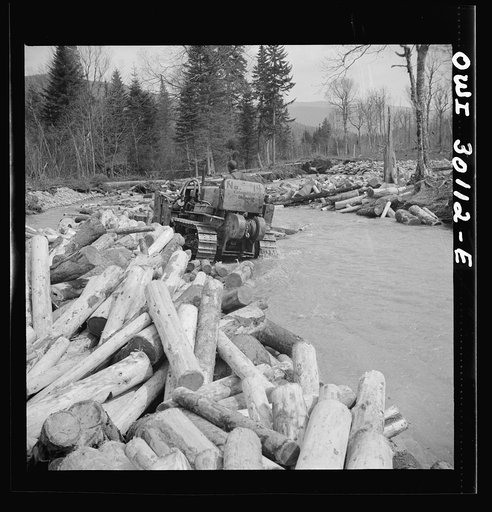 Untitled photo, possibly related to: Spring pulpwood drive on the Brown Company timber holdings in Maine. Bulldozer clearing a channel in Dennison Bog Brook so that another jam will not form