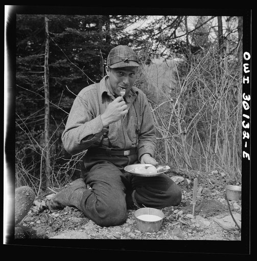Untitled photo, possibly related to: Spring pulpwood drive on the Brown Company timber holdings in Maine. The cook's assistant, "Cookie" dishing out pie at mid-morning lunch by the side of the road near where men are working