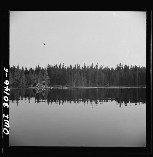 Spring pulpwood drive on the Brown Company timber holdings in Maine. Woodsmen winching up the boom on Long Pond; during the night the wind has blown the logs in the boom up pond away from the dam through which they must be sluiced