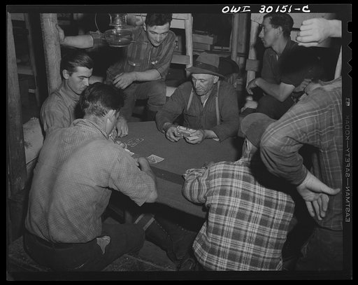 Spring pulpwood drive on the Brown Company timber holdings in Maine. Woodsmen playing cards in the bunk-house after thirteen hours of driving logs--the usual working day of the drive season. They are using Canadian money