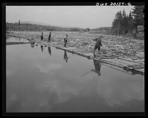 Spring pulpwood drive on the Brown Company timber holdings in Maine. Woodsmen with pikes feeding logs into the sluice at the power dam on the Kennebago River