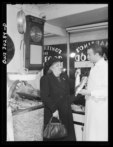 Mrs. Rose Carrendo buying fish from Joseph DeMartino, who buys his fish each morning from Fulton fish market. New York, New York