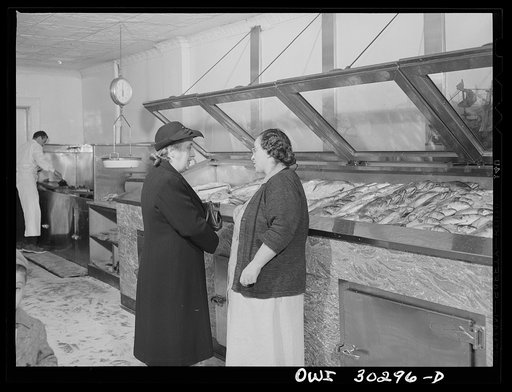 New York, New York. Mrs. Rose Carrendeno stops to chat with Mrs. DeMartino about the ration problems while Joseph DeMartino cleans the mackerel she has purchased