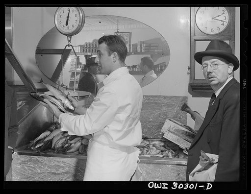 New York, New York. Joseph DeMartino weighing up fish for a customer in his mother's shop