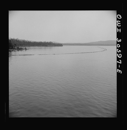 Spring pulpwood drive on the Brown Company timber holdings in Maine. The safety boom is anchored in a cove where it will not be in the way while the steamer is picking up the full boom