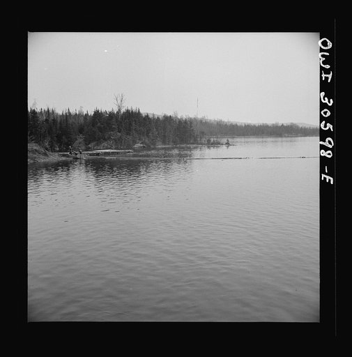 Spring pulpwood drive on the Brown Company timber holdings in Maine. The safety boom is anchored in a cove where it will not be in the way while the steamer is picking up the full boom
