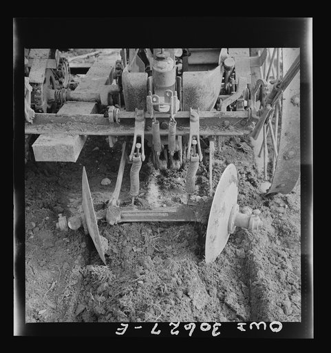 Spring potato planting on the French Acadian farm of Leonard Gagnon. Fort Kent, Aroostook County, Maine. Harrow of potato seeding machine
