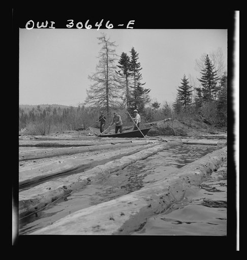 Spring pulpwood drive on the Brown Company timber holdings in Maine. Woodsmen in a "bateau" opening up on empty boom. These boats are used primarily to clean out logs which have been caught on snags or islands in the large streams and rivers