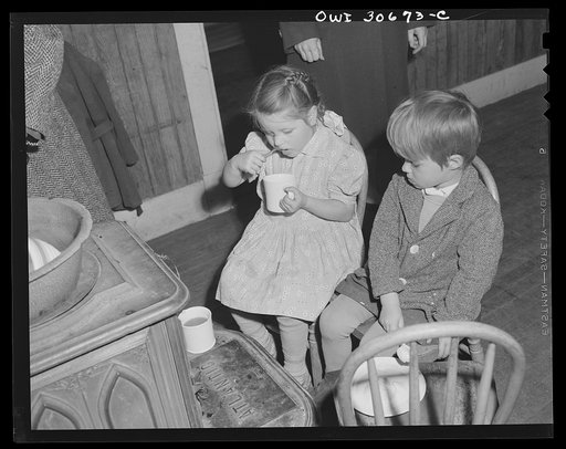 Buffalo Hill, Aroostook County, Maine. Youngest members of congregation trying to keep warm while eating cold refreshments served in the social period after a Congregational church service in a one-room school house