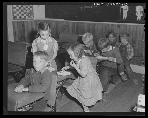 Untitled photo, possibly related to: Buffalo Hill, Aroostook County, Maine. Younger members of the congregation eat cookies, flavorade and homemade wild strawberry ice cream, refreshments served in the social period following a Congregational church service held in a one-room rural school house