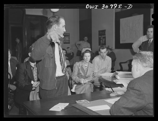 Untitled photo, possibly related to: OPA (Office of Price Administration) lawyers holding night hearings for offenders of the pleasure driving regulations. Pittsburgh, Pennsylvania. The man being sworn in has been stopped by policemen, accompanied by an OPA investigator. There was some question as t