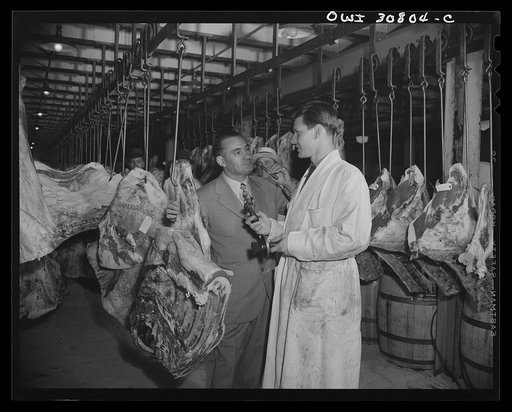 Untitled photo, possibly related to: A salesman and a patron in a wholesale meat market. A reconstruction photographed during the filming of "Black Marketing," a motion picture produced by the U.S. Office of War Information (OWI)