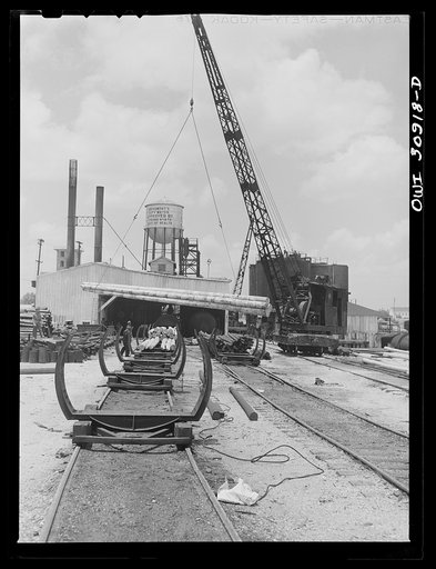 Beaumont, Texas. Loading poles for treatment at the International Creosoting plant