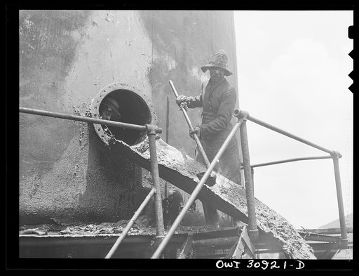 Untitled photo, possibly related to: Beaumont, Texas. Cleaning out a vat in which creosote is stored at the International Creosoting Company