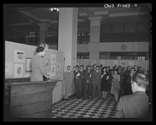 Untitled photo, possibly related to: New York, New York. Miss Anna Rosenberg of the War Manpower Commission, at the exhibition of cartoons concerning lost hours in war production, sponsored by the Office of War Information. She is looking at a cartoon, autographed by Mayor La Guardia of New York Cit
