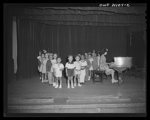 New York, New York. Phillipe Schuyler, child prodigy pianist, leading a group of children in the Harlem Center for Children in singing her arrangement of the Star Spangled Banner at the children's benefit for a nursery in Harlem