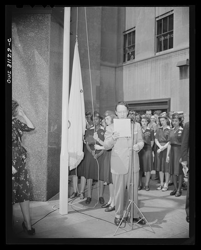 New York, New York. Radio announcer reading the preamble of the "Four Freedoms" while the flag is being raised, at the opening ceremonies at the Four Freedoms war bond show on the plaza of the International Building in Rockefeller Center