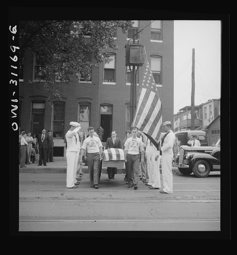 Merchant marine seaman given military funeral. Bearing the casket of Herman Sweitzer, one of the members of the merchant marine who lost his life in the recent ammunition ship-tanker collision off Norfolk. National Maritime Union men march through a Coast Guard color guard as they leave the Sweitzer