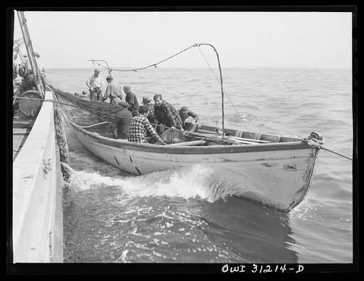 On board the fishing boat out of Gloucester, Massachusetts. Part of the crew adjusting the seining nets to the seining boat on the first morning out. Franasco Parisi checking the small motor. This operation is performed at ten knots per hour