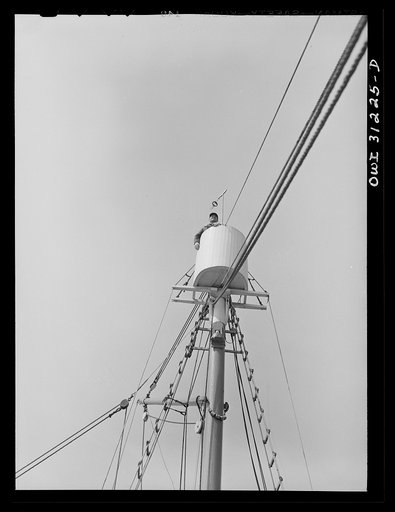 Untitled photo, possibly related to: Frank Mineo, owner of the Alden, climbs to the crow's nest to sight the mackerel school. Gloucester, Massachusetts