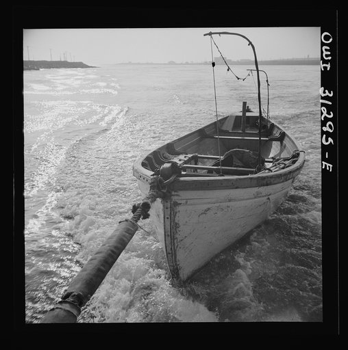 On board the fishing boat Alden out of Gloucester, Massachusetts. Seining boat being towed by the Alden