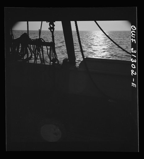 On board the fishing boat Alden, out of Gloucester, Massachusetts. Fishing schooner towing a dory off the New England coast