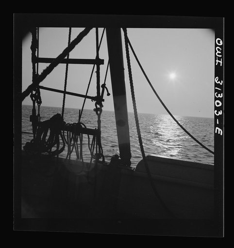 On board the fishing boat Alden, out of Gloucester, Massachusetts. Fishing schooner towing a dory off the New England coast
