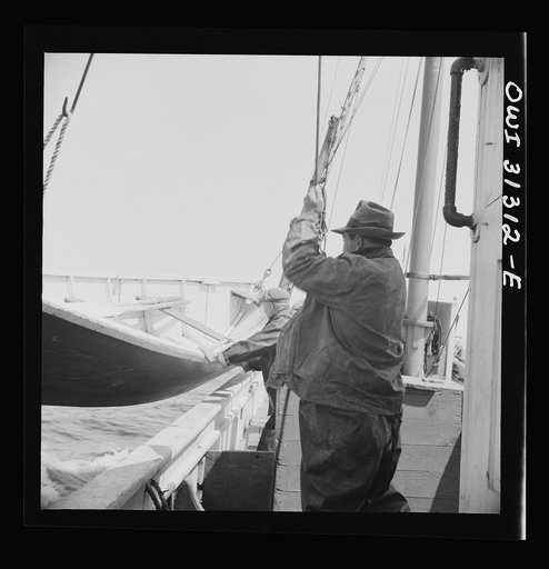 On board the fishing boat Alden, out of Gloucester, Massachusetts. Lowering a lifeboat over the side