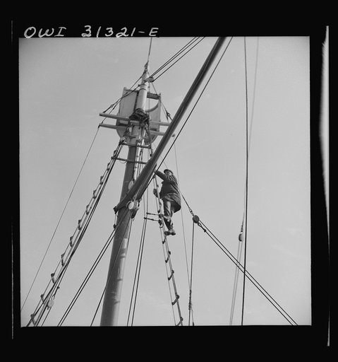 Frank Mineo, owner of the Alden, climbs to the crow's nest to sight the mackerel school. Gloucester, Massachusetts