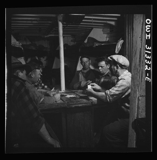 On board the fishing boat Alden, out of Gloucester, Massachusetts. Men playing cards as the ship heads home with a hold full of fish